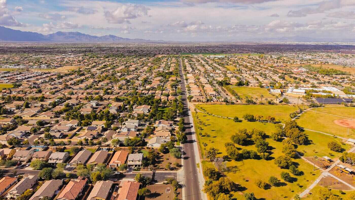 Aerial view of Arizona suburban rooftops and streets under a clear sky