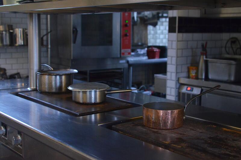 The stainless steel preparation line of a commercial restaurant kitchen