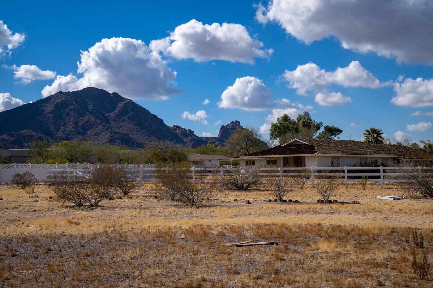 A rural Arizona house on open land with mountains behind it